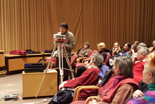 Bild zeigt Publikum und einen Teilnehmer während seines Redebeitrags