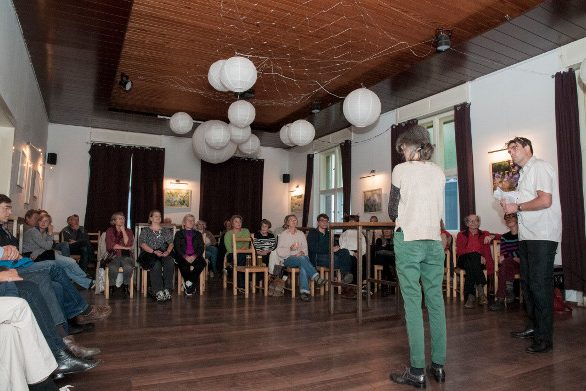 Bild zeigt Publikum, Moderator, Projektleiterin des Festivals STADTGESICHTER